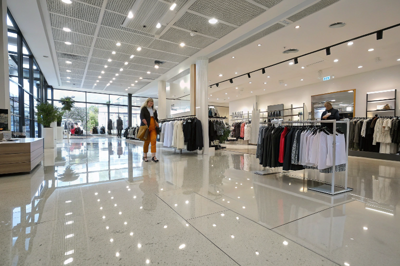 Modern Toowoomba retail clothing store with glossy epoxy flooring reflecting lights and customers shopping